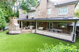 Spacious backyard with green lawn.