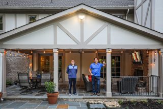Two men standing on patio.